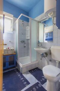 uma casa de banho com um chuveiro, um WC e um lavatório. em Apartments with a parking space Murter - 12067 em Murter