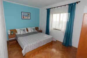 1 dormitorio con paredes azules y 1 cama con cortinas azules en Apartments with a parking space Pag - 12035 en Pag