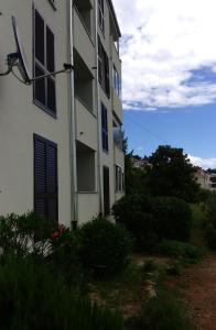 un edificio bianco con finestre e cespugli di fronte di Apartments with a parking space Rabac, Labin - 12100 a Rabac