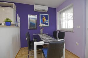 una sala da pranzo con pareti viola e tavolo e sedie di Apartments with a parking space Rabac, Labin - 12100 a Rabac Altre 7 foto