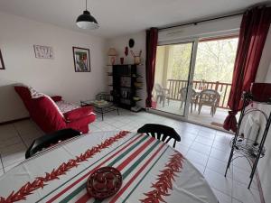- un salon avec un lit et un balcon dans l'établissement Appartement T2 calme avec terrasse et parking à Cambo-les-Bains, proche centre et thermes - FR-1-495-109, à Cambo-les-Bains