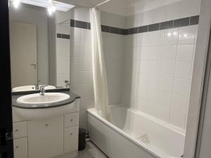 y baño con lavamanos, bañera y lavamanos. en Appartement Cambo-les-Bains, 2 pièces, 3 personnes - FR-1-495-109, en Cambo-les-Bains