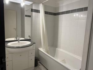 une salle de bain avec un lavabo et une baignoire et un lavabo dans l'établissement Appartement T2 calme avec terrasse et parking à Cambo-les-Bains, proche centre et thermes - FR-1-495-109, à Cambo-les-Bains