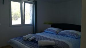 a bed with two towels on it with a window at Seaside house for families with children Cove Vitane, Pasman - 12141 in Tkon