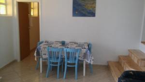 a dining room table with blue chairs and a painting at Seaside house for families with children Cove Vitane, Pasman - 12141 in Tkon