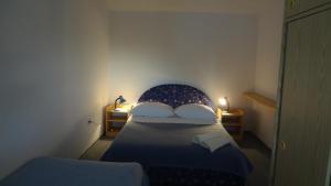 ein kleines Schlafzimmer mit einem Bett mit zwei Lampen in der Unterkunft Apartments by the sea Tribunj, Vodice - 12144 in Tribunj