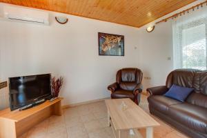 a living room with a couch and a flat screen tv at Apartments with a parking space Nerezine, Losinj - 12149 in Nerezine