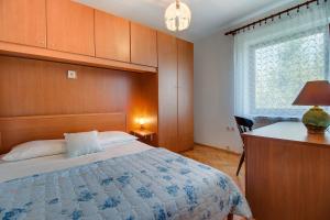 a bedroom with a bed and a desk and a window at Apartments with a parking space Nerezine, Losinj - 12149 in Nerezine