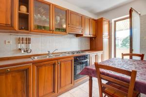 a kitchen with wooden cabinets and a sink and a table at Apartments with a parking space Nerezine, Losinj - 12149 in Nerezine