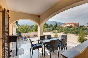 a balcony with a table and chairs and a view at Apartments with a parking space Nerezine, Losinj - 12149 in Nerezine