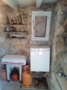 Il comprend une petite cuisine avec une cuisinière et une fenêtre. dans l'établissement Secluded fisherman's cottage Radelj, Murter - 12155, à Murter