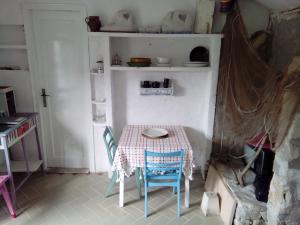 une petite table et des chaises dans une petite pièce avec une table dans l'établissement Secluded fisherman's cottage Radelj, Murter - 12155, à Murter