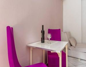 stół z butelką wina i fioletowymi krzesłami w obiekcie Apartments with WiFi Split - 12154 w Splicie