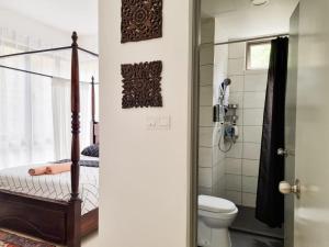 ein Bad mit einer Dusche und einem WC in der Unterkunft Mossy Forest Family Retreat, Kea Farm Brinchang in Brinchang