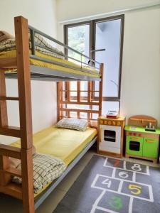 Mossy Forest Family Retreat, Kea Farm Brinchang في برينشانغ: غرفة نوم بسريرين بطابقين وموقد