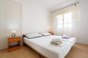 a white bedroom with a bed and a window at Apartments by the sea Basina, Hvar - 11817 in Vrbanj
