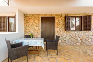 a patio with a table and chairs and a stone wall at Apartments by the sea Basina, Hvar - 11817 in Vrbanj +26 photos