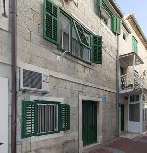 a building with green shutters on the side of it at Apartments by the sea Baska Voda, Makarska - 12209 in Baška Voda