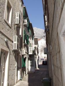 an alley with buildings and a car on a street at Apartments by the sea Baska Voda, Makarska - 12209 in Baška Voda