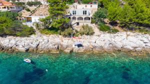 a boat in the water next to a rocky shore at Apartments by the sea Cove Zaglav, Korcula - 12208 in Prizba