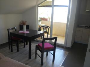 een eetkamer met een tafel en stoelen en een keuken bij Apartments with a parking space Vodice - 12206 in Vodice
