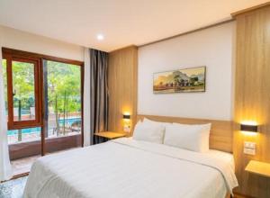 Un dormitorio con una gran cama blanca y una ventana en New Champa Boutique Hotel en Vientián