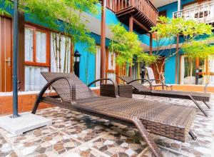 two wooden benches sitting in front of a building at New Champa Boutique Hotel in Vientiane