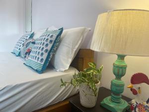a bedroom with a bed with a lamp and a plant at Sun-kissed Holidays, Goa Topaz in Candolim