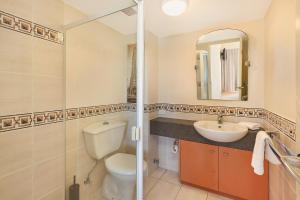 uma casa de banho com um WC, um lavatório e um espelho. em PICNIC7- PICTURE PERFECT PICNIC POINT em Maroochydore