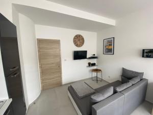 a living room with a couch and a tv at 010-Superbe appartement bien décoré netflix gratuit in Charleroi