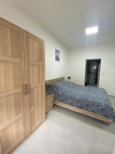 a bedroom with a bed and wooden cabinets at 010-Superbe appartement bien décoré netflix gratuit in Charleroi