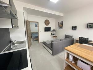 cocina y sala de estar con sofá y mesa en 010-Superbe appartement bien décoré netflix gratuit en Charleroi