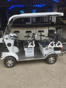 Un carrito de golf con tres taburetes. en Galaxy Suites, en Pattaya South