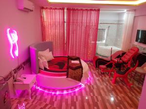 Habitación de color rosa con cama y silla en Tina 2 Hotel, en Cái Răng