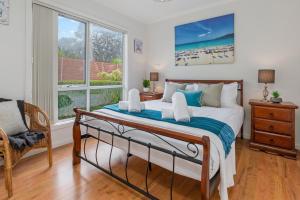 a bedroom with a bed with a view of the beach at SEArenity in Rosebud