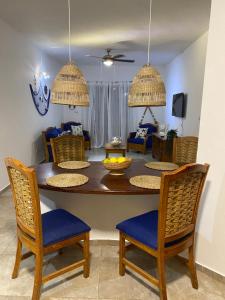 a dining room with a table with chairs and a living room at Espectacular BZII, bayahibe in Bayahibe