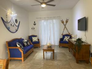 sala de estar con sillas azules y TV en Espectacular BZII, bayahibe, en Bayahibe