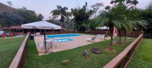 um quintal com uma piscina e uma tenda em Espaço Rural Água da Onça em Guararema