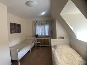 1 dormitorio con 2 camas y ventana en Top Lage! Charmantes Landhaus 5 Geh-Min v. Strand, en Timmendorfer Strand
