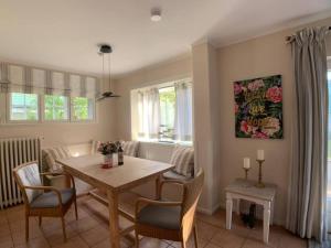 un salon avec une table et des chaises de salle à manger dans l'établissement Top Lage! Charmantes Landhaus 5 Geh-Min v. Strand, à Timmendorfer Strand