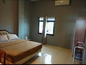 Mandai的住宿－The Carstensz Homestay，一间卧室设有一张大床和两个窗户。