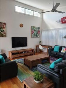 a living room with a couch and a tv at Double 10 in Rainbow Beach