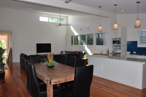 a dining room and living room with a table and chairs at Double 10 in Rainbow Beach
