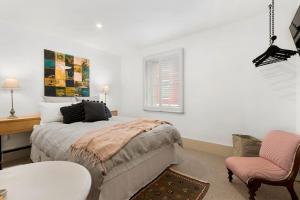 een slaapkamer met een bed, een tafel en een stoel bij Tori's Luxury Historic Cottage - Walk Salamanca in Hobart