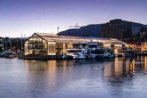 a large building on the water with boats in it at Tori's Luxury Historic Cottage - Walk Salamanca in Hobart