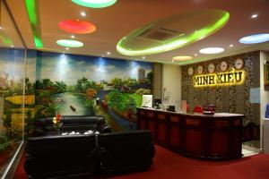 a bar in a hotel with a large painting on the wall at Minh Kieu Hotel in My Tho
