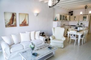 a living room with a white couch and a table at Tholaria Boutique Hotel in Astypalaia Town