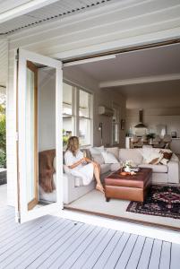 a woman sitting on a couch in a living room at Bridport Beach House in Bridport