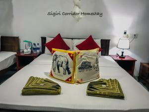 a bed with two towels and two pillows on it at Sigiri Corridor Home Stay in Sigiriya