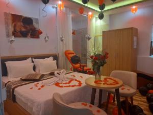 Un dormitorio con una cama y una mesa con flores. en Tina 2 Hotel en Cái Răng